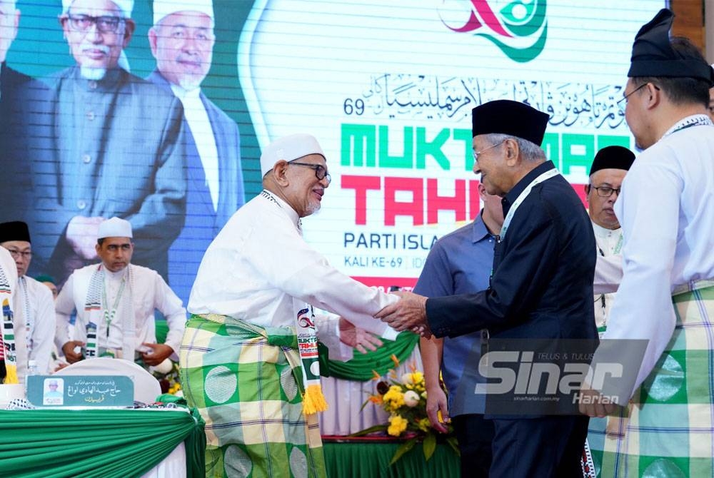 Abdul Hadi (kiri) menyambut kehadiran Dr Mahathir pada Muktamar Tahunan Pas ke- 69 di Ideal Convention Centre (IDCC) pada Jumaat. - Foto Sinar Harian / MOHD HALIM ABDUL WAHID.