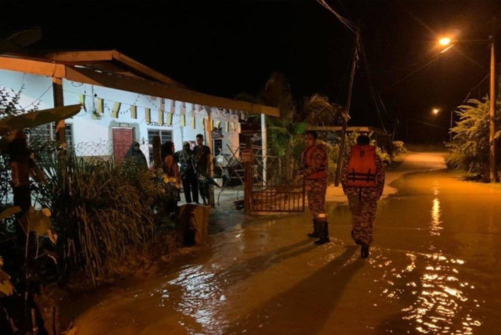 Anggota bomba membantu menyelamatkan mangsa banjir di di daerah Batang Padang pada Jumaat. - Foto Awani