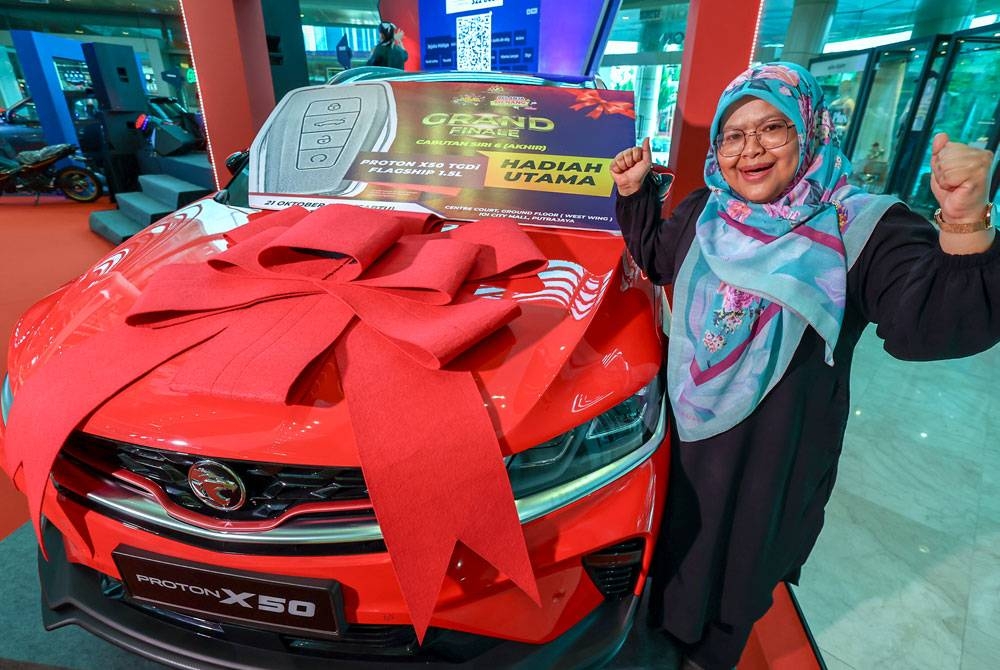 Norhashimah ceria bersama hadiah utama sebuah kereta Proton X50 yang dimenanginya pada cabutan bertuah "Belanja dan Menang" Program Jualan Malaysia 2022 Siri 6 (Akhir) di IOI City Mall pada Sabtu.