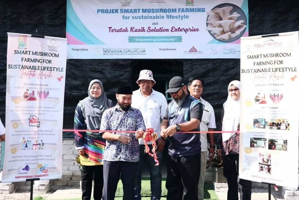 Asmadi (kanan) menyempurnakan majlis penyerahan rumah cendawan di Bukit Sekilau.