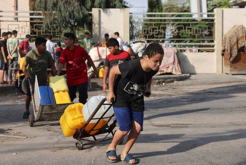 Orang ramai mengangkut air di Rafah di selatan Semenanjung Gaza pada Ahad, di tengah-tengah pertempuran berterusan antara Israel dan Hamas. - Foto AFP