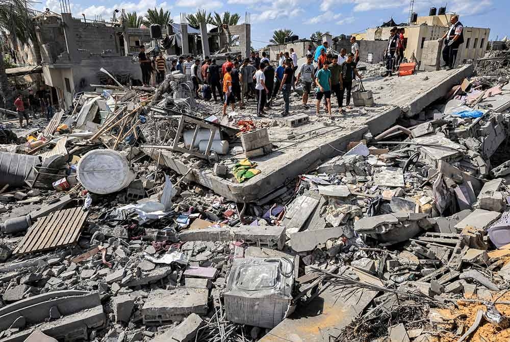 Penduduk memeriksa rumah yang musnah dibedil tentera Israel di Khan Yunis, selatan Genting Gaza. - AFP