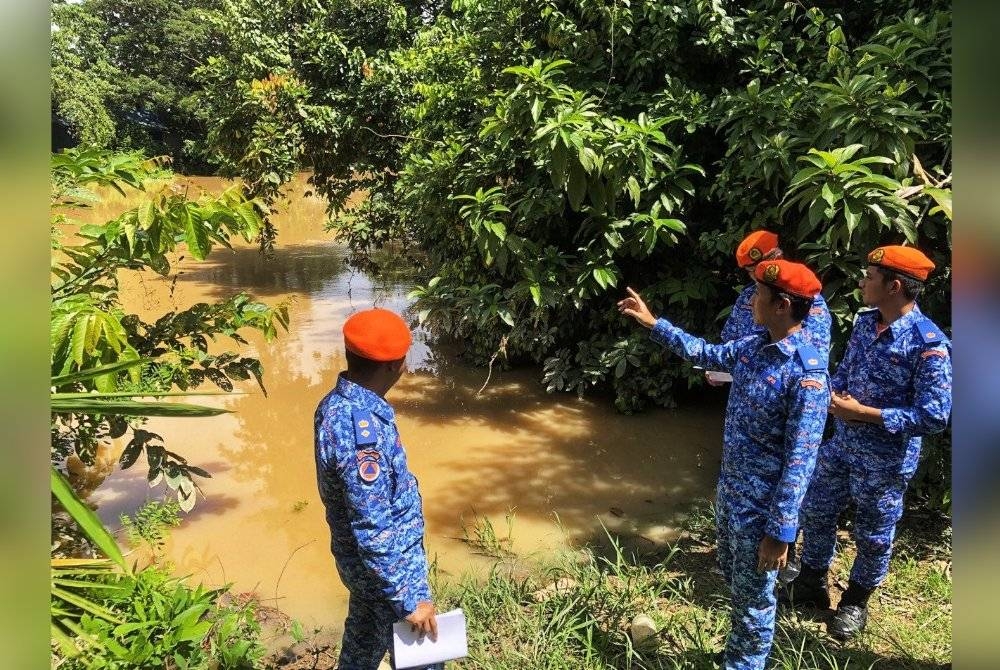 Zairil Anuar (dua dari kiri) meninjau keadaan sungai Anak Bukit, di sini pada Isnin.