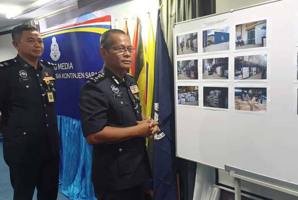 Shahurinain (depan) menunjukkan gambar rampasan daging dan ayam sejuk beku di dua premis di Penampang dalam sidang akhbar di IPK Sabah.