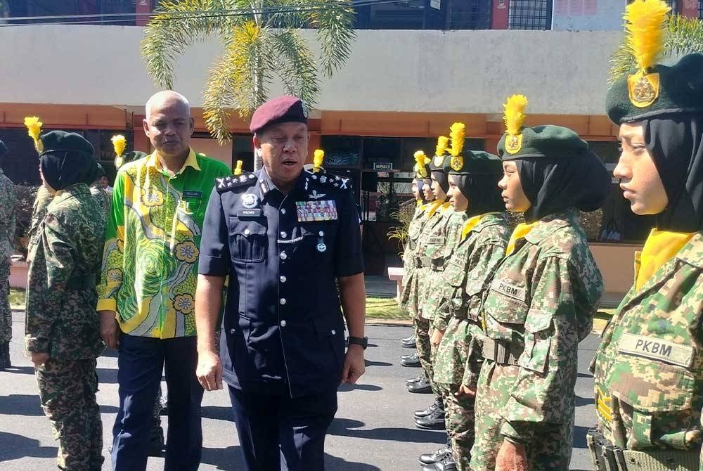 Hazani (depan) memeriksa perbarisan kawad statik pelajar sebelum merasmikan Majlis Hari Anugerah Cemerlang SMK Sik pada Isnin.