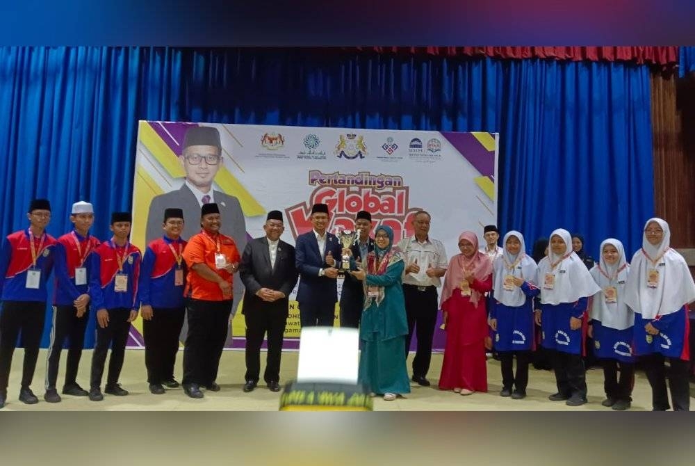 Mohd Fared (tengah) menyampaikan piala pusingan kepada johan keseluruhan Pertandingan Global Wakaf Game Negeri Johor 2023 di Dewan Utama MPC, Bandar Baru Uda, Johor Bahru pada Isnin.