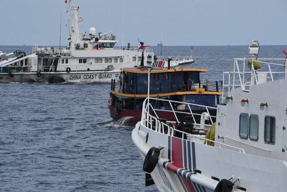 Kapal Pengawal Pantai China (kanan) mengepung bot awam disewa tentera laut Filipina untuk menghantar bekalan kepada kapal tentera laut di Second Thomas Shoal. - Foto AFP