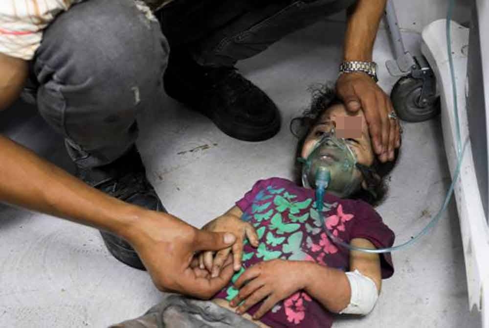 Seorang kanak-kanak Palestin yang cedera akibat serangan udara tentera Zionis Israel menunggu untuk mendapatkan rawatan di Hospital Shifa, Gaza. - Foto AP