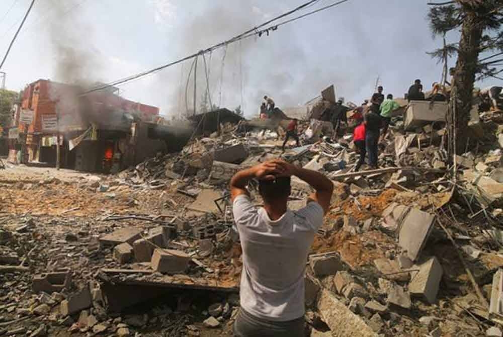 Rakyat Palestin lakukan usaha menyelamat mangsa yang terperangkap di bawah runtuhan bangunan susulan serangan udara tentera Zionis Israel di Rafah. - Foto AP