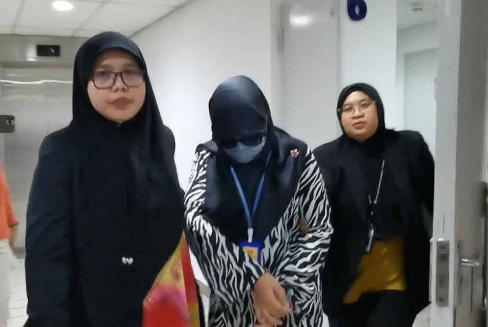 Tertuduh (tengah) dihadapkan ke Mahkamah Sesyen di Kuala Terengganu pada Selasa atas sembilan pertuduhan salah guna kuasa melibatkan kerja-kerja perolehan bekalan.