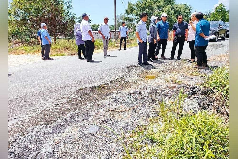 Mohamad Fazli (tengah) meninjau projek Jalan Kampung Rahmat pada Selasa.