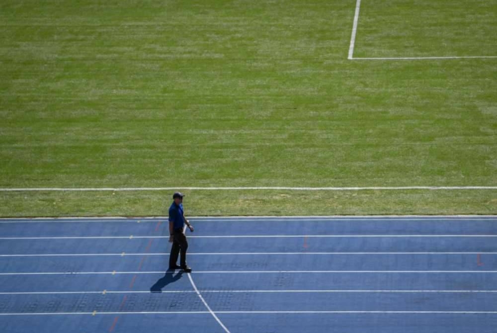 Seorang lelaki berjalan di padang yang baru ditukar kepada jenis rumput Zeon Zoysia pada Perasmian Padang Stadium Nasional baru-baru ini. - Foto Bernama