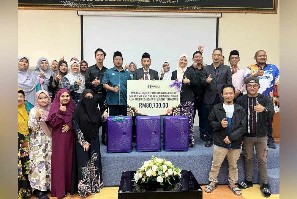 Shaikh Harun (tengah) bersama penerima yang diraikan sempena Majlis Anugerah Insentif Pakej Umrah di Kompleks Darul Hidayah di Kuala Terengganu.