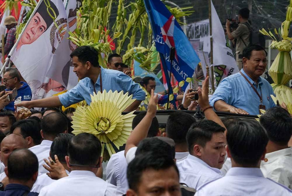 Prabowo (kanan) dan Gibran diiringi penyokong ketika mendaftarkan diri untuk menjadi calon Presiden dan Naib Presiden di ibu pejabat KPU di Jakarta pada Rabu. - AFP