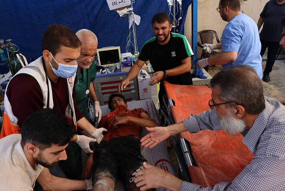 Doktor dan petugas hospital merawat mangsa serangan udara Israel di sebuah hospital di Rafah. - AFP