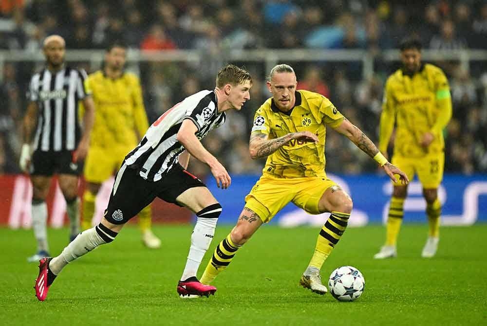 Pemain tengah Newcastle, Anthony Gordon (kiri) cuba merebut bola daripada penguasaan pemain Dortmund, Marius Wolf. - Foto AFP