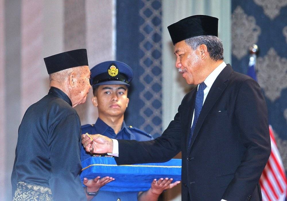 Mohamad menyampaikan Pingat Jasa Malaysia kepada penerima.