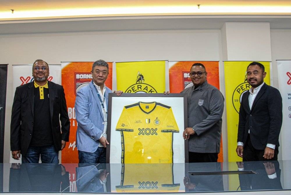 Roy Ho (dua dari kiri) menyampaikan replika jersi Perak FC sebagai cenderahati kepada Nabil Husein selepas menandatangani MoU kerjasama di antara Perak FC dengan Borneo FC Samarinda di Ibu Pejabat XOX Berhad di Kuala Lumpur pada Khamis. - Foto PERAK FC