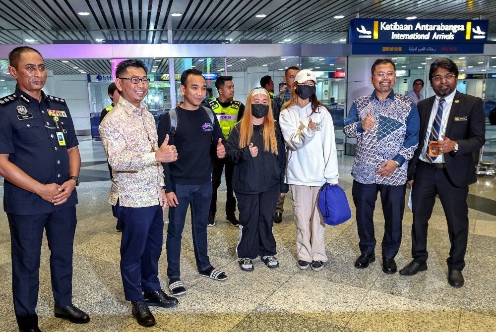 Mohamad Alamin (dua dari kiri) menyambut kepulangan rakyat Malaysia yang diselamatkan daripada menjadi mangsa pemerdagangan manusia sindiket Macau Scam di Peru sebaik tiba di KLIA pada Khamis. - Foto Bernama