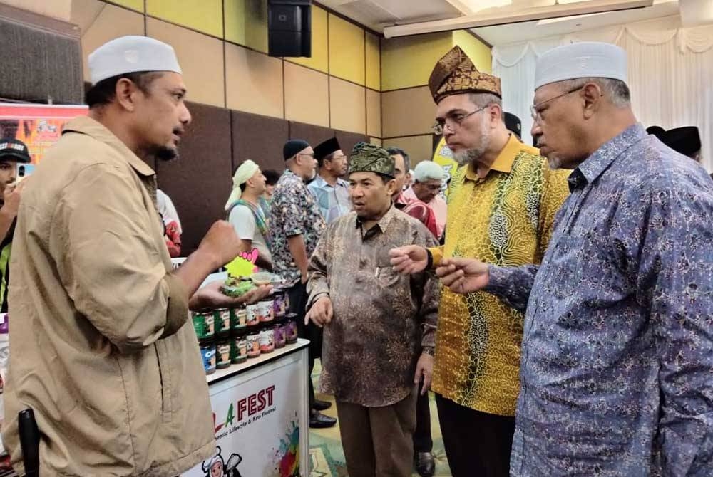 Mohamad Nasriff (dua dari kanan) mendengar perkongsian usahawan mengenai produk keluaran mereka ketika Majlis Perasmian Kala Fest 2023 di sini pada Khamis. Turut kelihatan, Hadir sama, Ahmad (kanan).