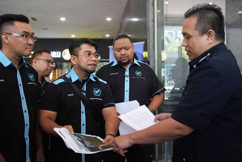 Hishamuddin (dua dari kiri) menyerahkan dokumen dan laporan mangsa sindiket penipuan membina rumah kepada seorang pegawai JSJK Bukit Aman di Menara KPJ, Jalan Tun Razak, Kuala Lumpur pada Jumaat.