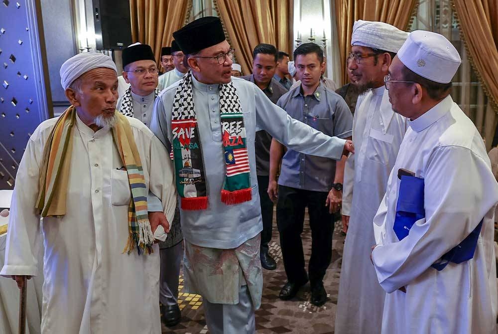 Perdana Menteri Datuk Seri Anwar Ibrahim bersama Mudir Pertubuhan Mujamma` Ibnu Sunni Lit Talaqqi Pendang Kedah Abdullah Abdul Rahman @ Abdul Rahim (kiri) beramah mesra dengan para hadirin semasa Majlis Ilmu Madani di Seri Perdana malam ini - Foto Bernama.