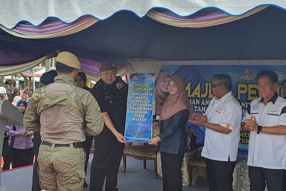 Fadhlina (tiga dari kanan) dan Kok Chin (kiri) ketika melancarkan Taman Angkat Amanita Taman Pekaka Seberang Perai Selatan di Sekolah Menengah Kebangsaan Saujana Indah pada Sabtu.