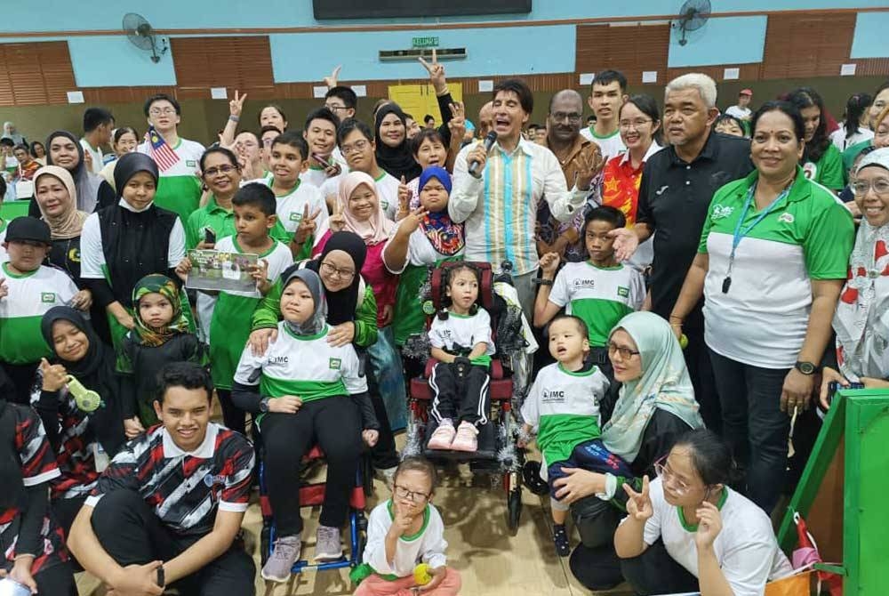 DJ Dave dan Mei Sze (berdiri, empat dari kanan) beramah mesra bersama tetamu pada Karnival Sukan Kanak-Kanak OKU di Dewan D’ Kelana Kompleks Sukan MBPJ Kelana Jaya, Petaling Jaya pada Sabtu.