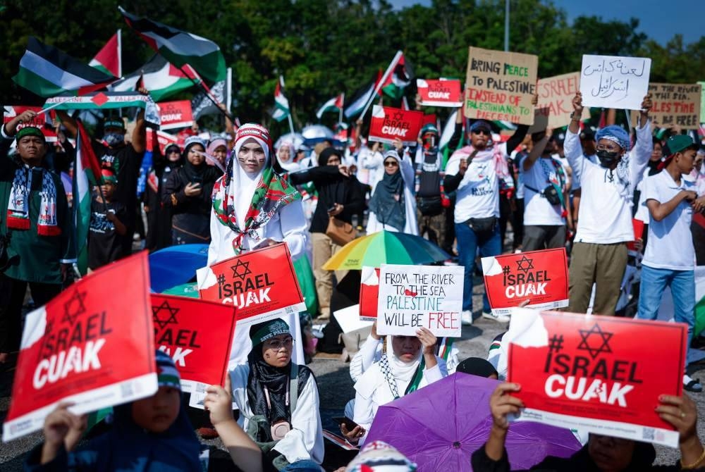 Orang ramai berkumpul sambil membawa bendera Palestin dan sepanduk sebagai tanda menyatakan solidariti terhadap rakyat negara itu pada Jelajah Satu Juta Pembela Palestin di pekarangan Stadium Hang Jebat dekat Krubong hari ini. - Foto Bernama