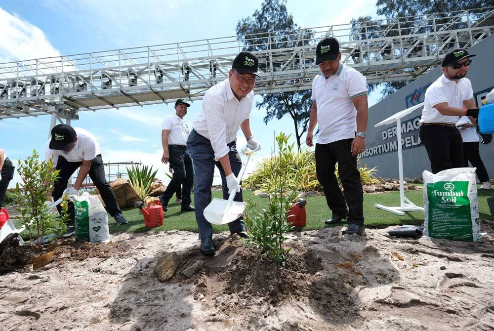 Ahmad Amzad (kiri) menanam anak pokok pada program ‘KPK Grow Green 2023-Tree Planting at East Wharf’ di Dermaga Timur, Pelabuhan Kemaman pada Ahad.