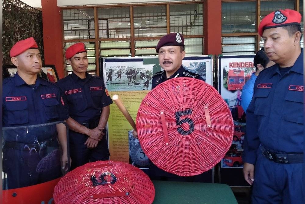 Mohd Yusri (dua dari kanan) mencuba peralatan yang dipamerkan sempena Program Pencegahan Jenayah dan Meniti Kerjaya Dalam PDRM di Sekolah Menengah Kebangsaan (SMK) Sungai Pari di sini pada Isnin.