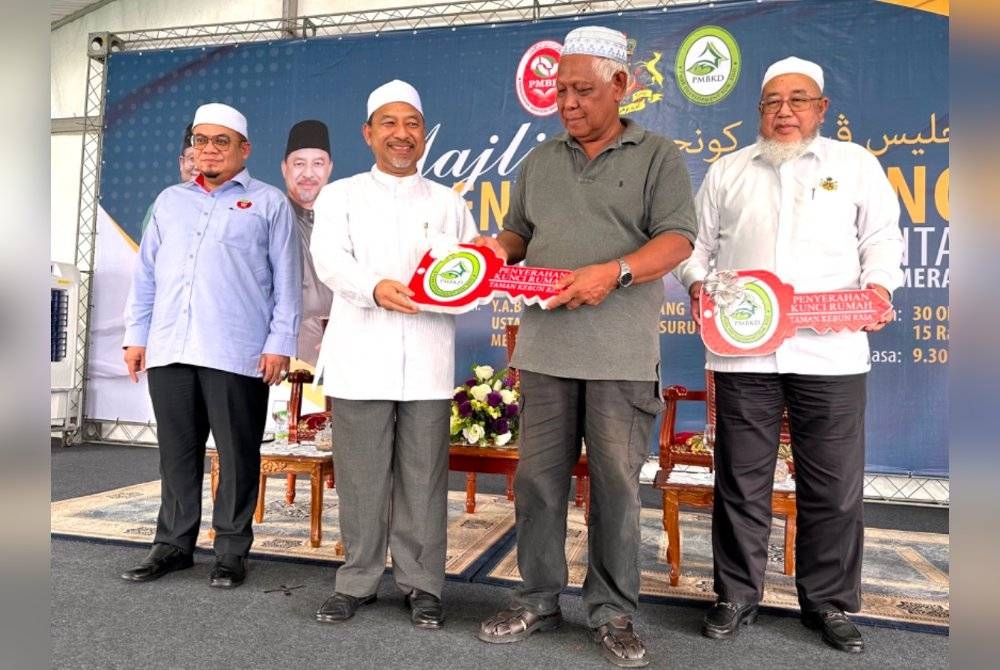 Simbolik penyerahan kunci RMMK daripada Mohd Nassuruddin (dua dari kiri) kepada pembeli, Marzuki Halim (dua dari kanan).