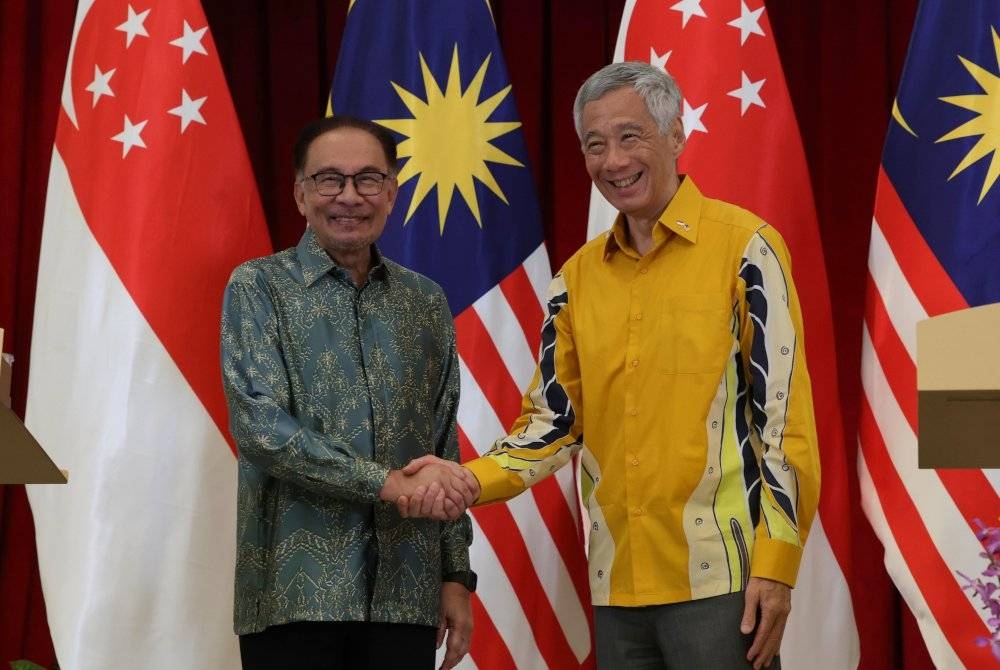 Anwar (kiri) bersalaman dengan rakan sejawatnya dari Singapura, Lee Hsien Loong selepas sidang media bersama setelah Sesi Permukiman Pemimpin-Pemimpin Malaysia-Singapura di Istana hari ini. - Foto Bernama