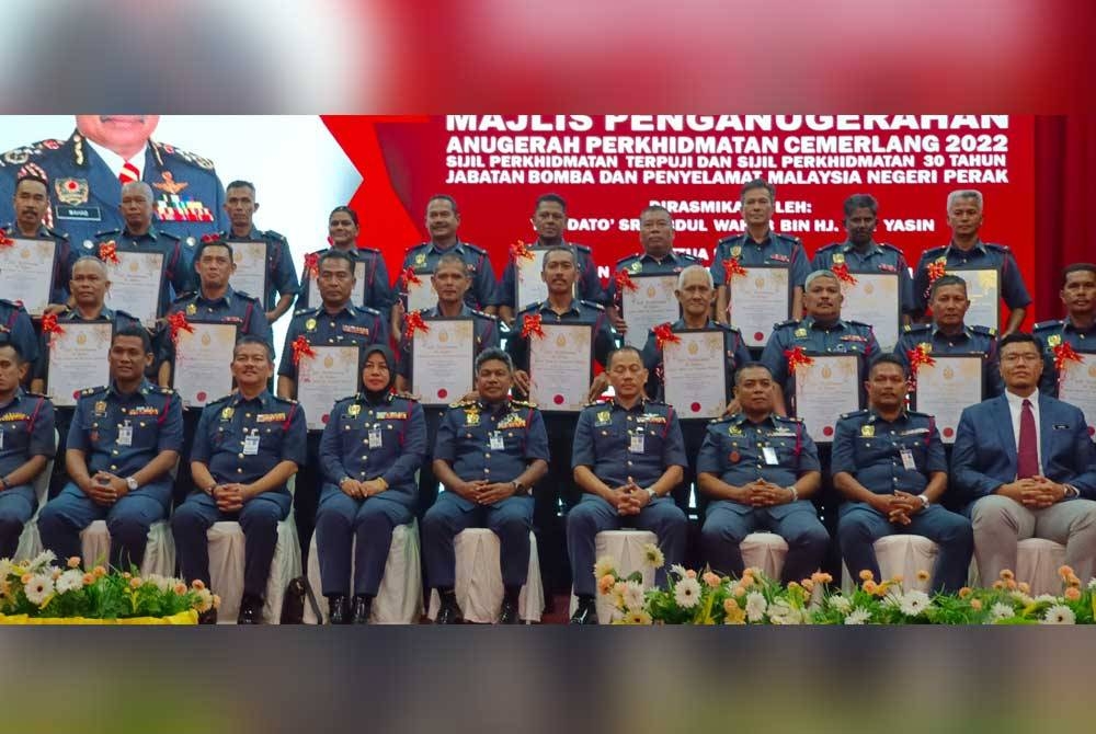 Abdul Wahab (duduk, tengah) bergambar bersama penerima Sijil 30 Tahun Perkhidmatan di JBPM Perak pada Isnin.