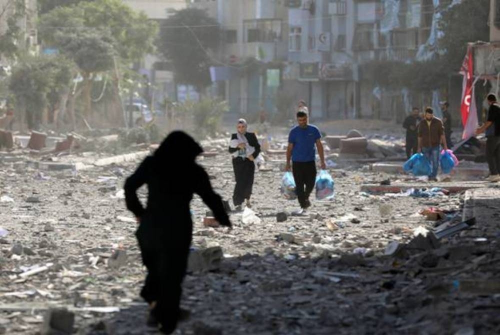 Beberapa rakyat Palestin meninggalkan kediaman mereka yang telah dibom oleh zionis Israel, pada Isnin. - Foto AP