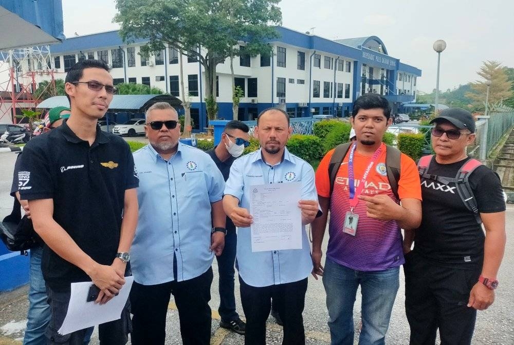 Kamarul Baharin (tengah) bersama sebahagian pekerja MYAirline membuat laporan polis di IPD Sepang, Selangor pada Selasa.