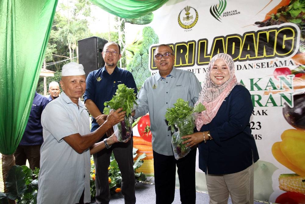 Mohd Zolkafly (dua dari kanan) menyampaikan bekalan sayuran percuma kepada pengunjung yang hadir sempena Hari Ladang Daerah Larut Matang Selama (LMS) dan Pelancaran Kempen Makan Sayur-sayuran peringkat negeri Perak di Pejabat Pertanian Daerah LMS dekat Taiping pada Selasa.