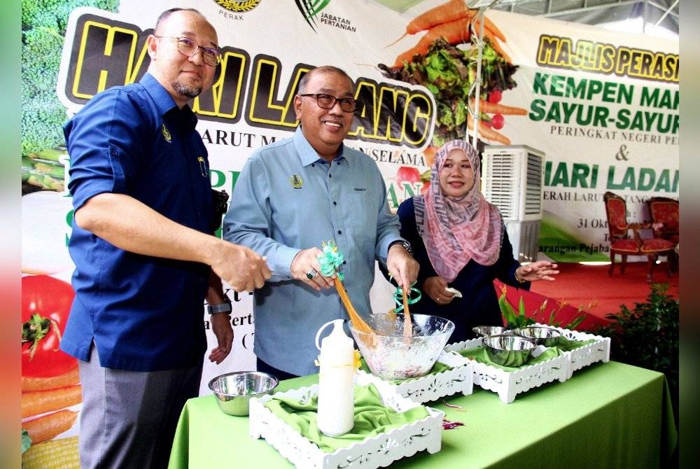 Mohd Zolkafly (tengah) melakukan demonstrasi menyediakan salad daripada hasil pengeluaran program pembangunan pertanian komuniti sempena Hari Ladang Daerah Larut Matang Selama (LMS) dan Pelancaran Kempen Makan Sayur-sayuran peringkat negeri Perak di Pejabat Pertanian Daerah LMS dekat Taiping pada Selasa.