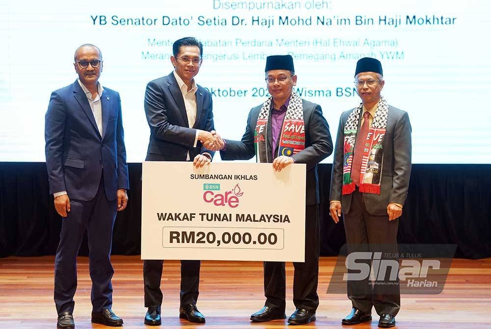 Mohd Na&#039;im menerima sumbangan dari Ketua Eksekutif Bank Simpanan Nasional, Jay Khairil disaksikan oleh Ketua Pegawai Eksekutif Yayasan Waqaf Malaysia, Dr. Ridzwan Bakar (kanan) dan Ketua Pegawai Perniagaan Bank Simpanan Nasional, Mujiburrahman Abdul Rashid (kiri) pada majlis Pelancaran Kerjasama Strategik Wakaf Tunai Malaysia Antara Bank Simpanan Nasional Dan Yayasan Waqaf Malaysia yang diadakan di Wisma BSN, Kuala Lumpur pada Selasa. - Foto Sinar Harian/Rosli Talib