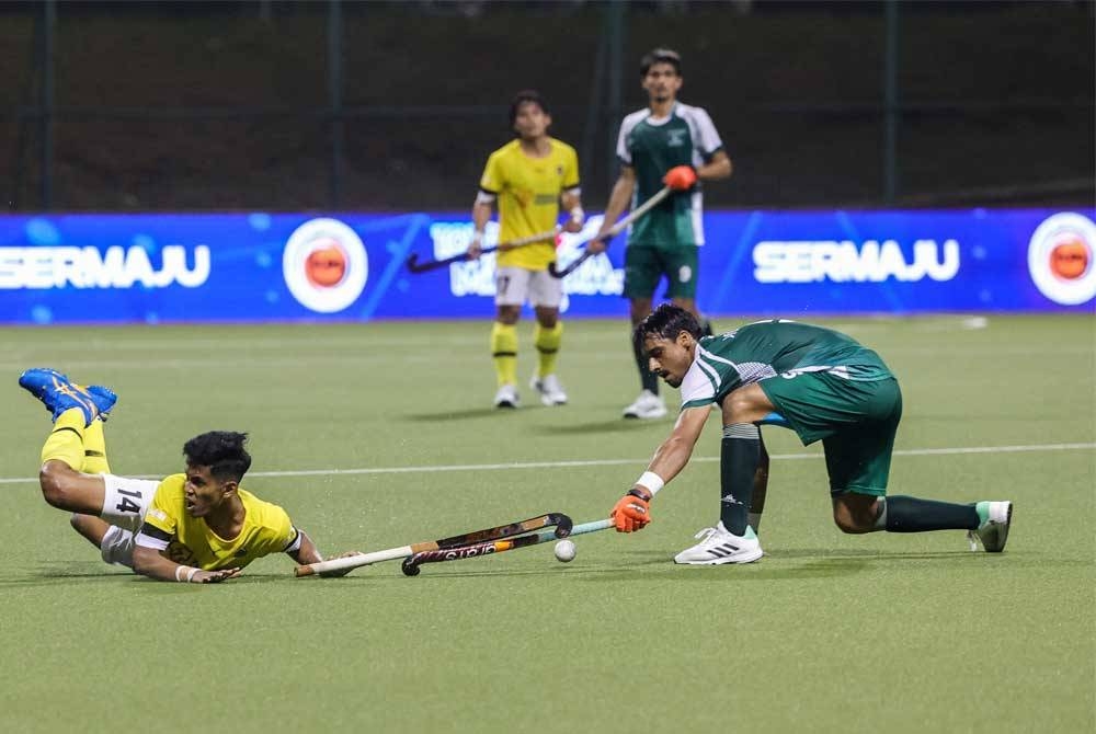 Pemain Malaysia, Nur Aqilrullah Che Ashraf (kiri) diasak pemain Pakistan, Muhammad Murtaza (kanan) pada Perlawanan Hoki Piala Sultan Johor (SOJC) di Stadium Hoki Taman Daya hari ini. - Foto: Bernama