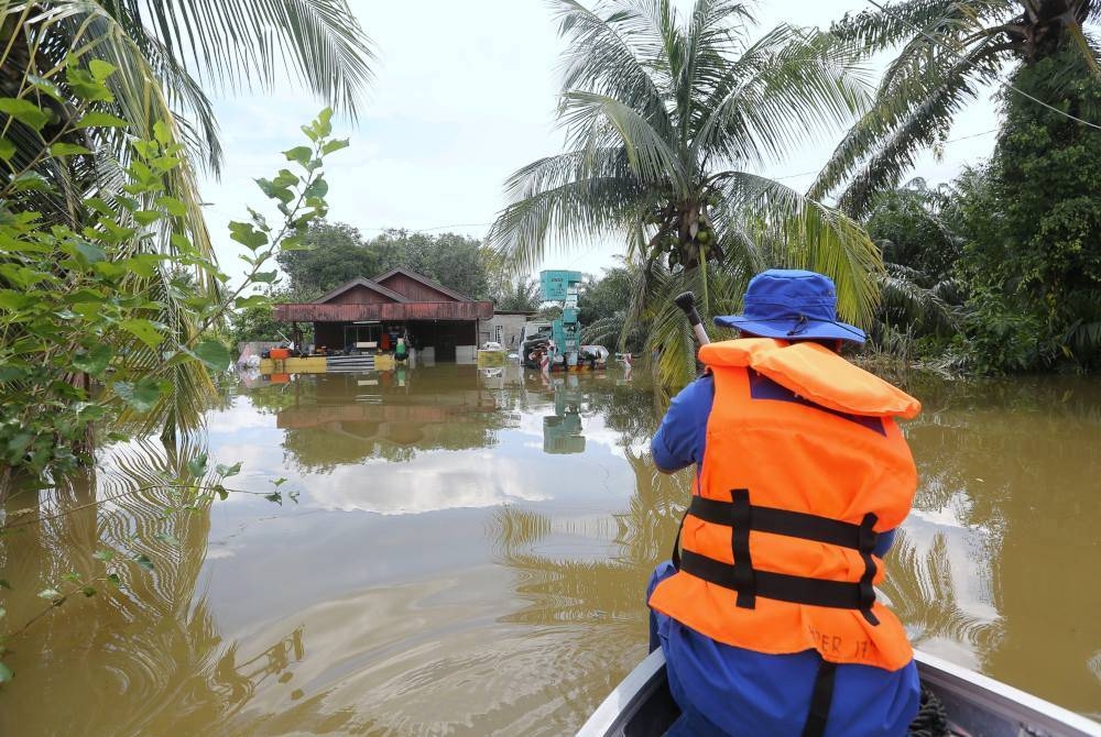 Anggota Angkatan Pertahanan Awam (APM) Daerah Hilir Perak meninjau kawasan rumah penduduk yang terjejas akibat banjir ketika tinjauan di Batu 9, Jalan Changkat Jong pada Selasa. - Foto Bernama