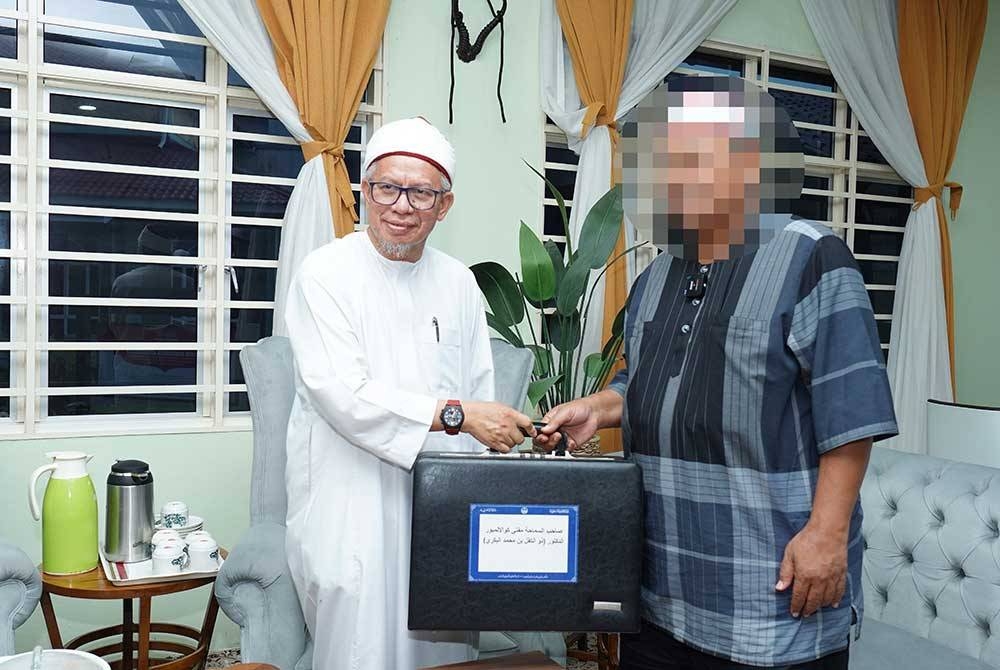 Zulkifli menyerahkan jam Rolex kepada pembida di pejabatnya pada Rabu.