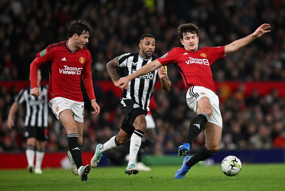 Harry Maguire (kanan) mengawal bola ketika aksi Piala Liga menentang Newcastle United. - Foto AFP