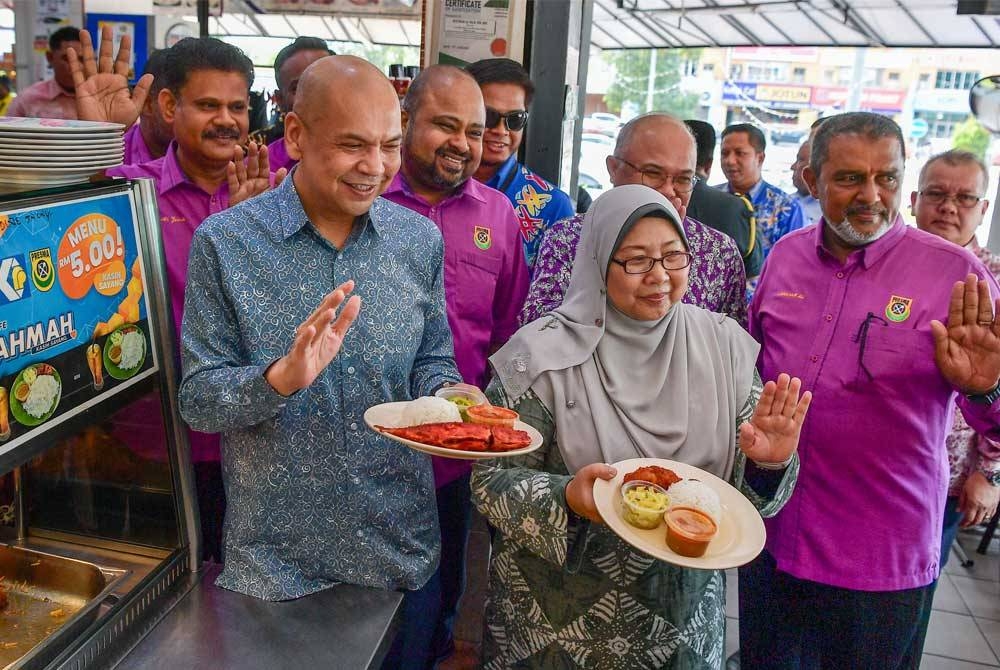 Armizan (kiri) dan Timbalan Menteri KPDN, Fuziah Salleh menunjukkan lauk menu Rahmah selepas sidang akhbar Kad Diskaun Khas Menu Rahmah di Restoran Ali Maju. Foto Bernama