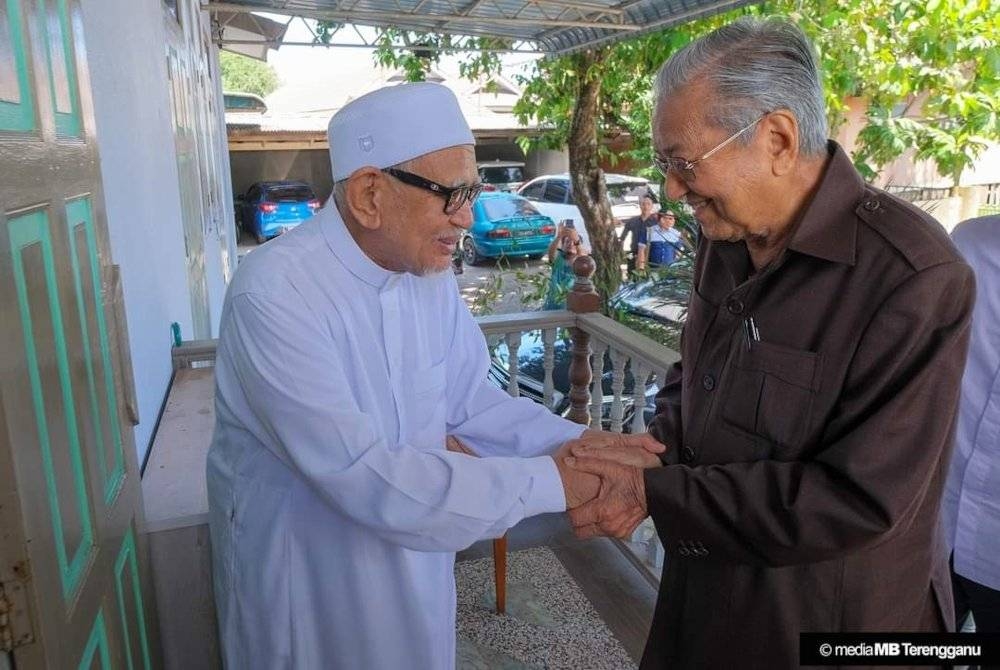 Dr Mahathir disambut Abdul Hadi ketika tiba ke teratak Presiden Pas itu di Rusila, Marang pada Khamis. - Foto Ihsan Media MB Terengganu