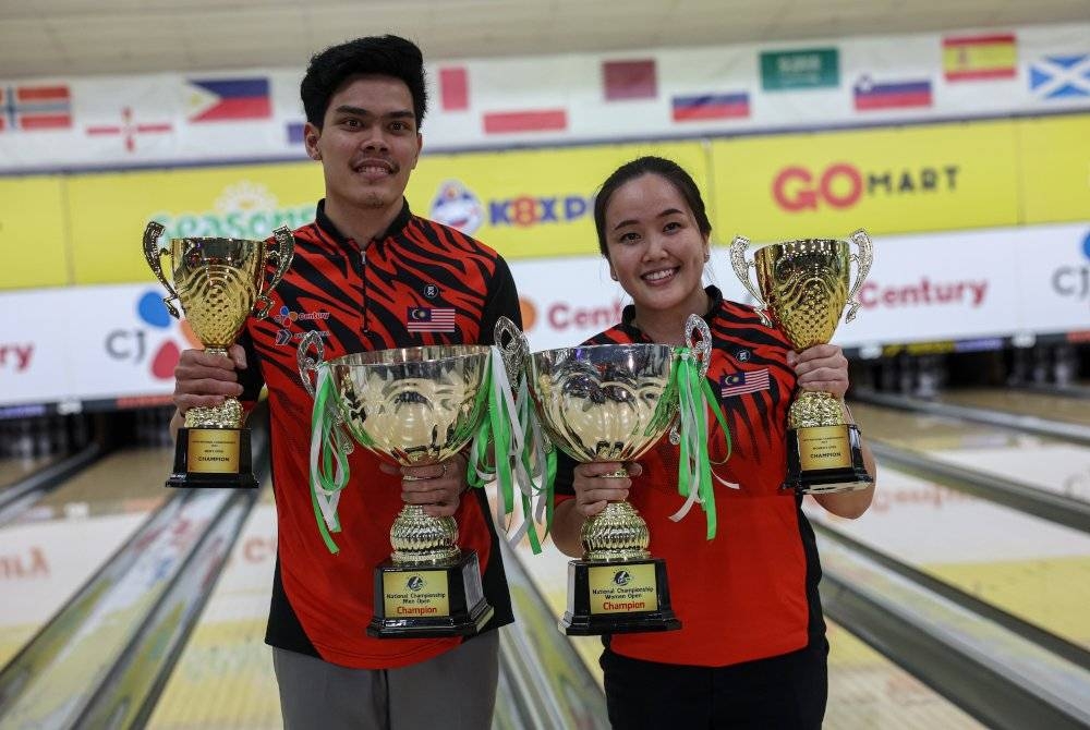 Atlet bowling negara Muhammad Syazirol Shamsudin dan Sin Li Jane menunjukkan piala kejuaraan yang dimenangi mereka pada Masters Terbuka Lelaki dan Wanita Kejohanan Boling Kebangsaan ke-45 di Sunway Mega Lanes, Bandar Sunway malam Khamis. - Foto Bernama