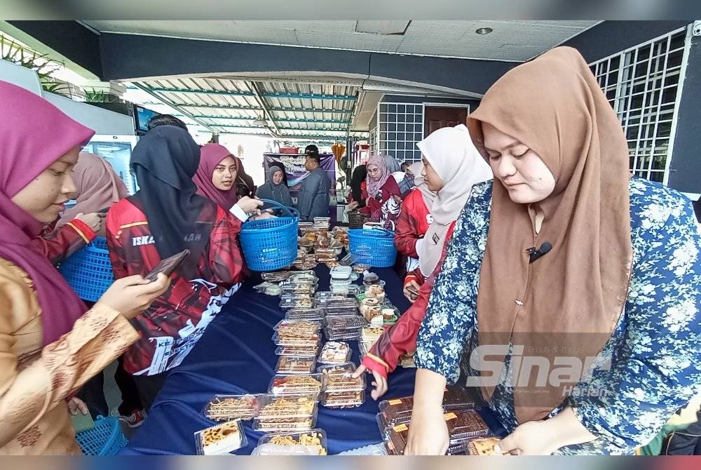 Noorwarda (kanan) tidak menang tangan melayan pelanggan yang membeli aneka makanan berharga RM3 dijualnya.