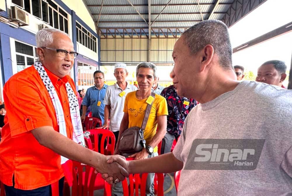 Mahfuz (kiri) bersalaman dengan perwakilan yang hadir pada Mesyuarat Tahunan Amanah Kawasan Pasir Mas pada Jumaat.