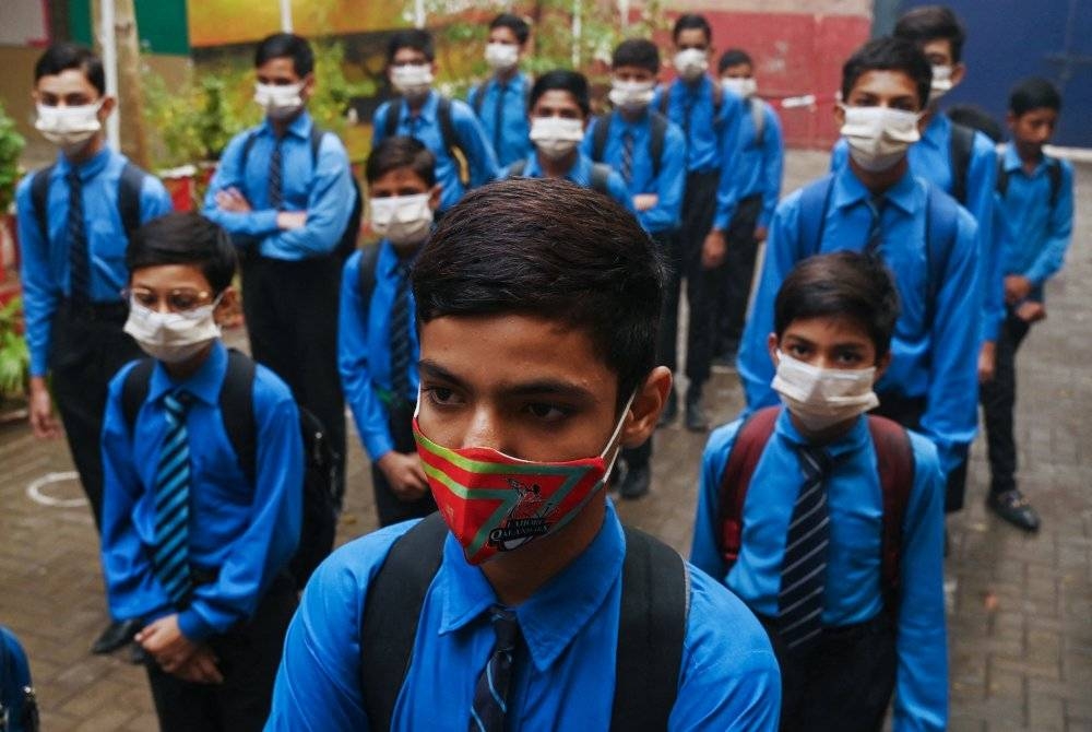 Pelajar memakai pelitup muka semasa tiba di sekolah di Lahore ketika jerebu melanda wilayah itu. - AFP