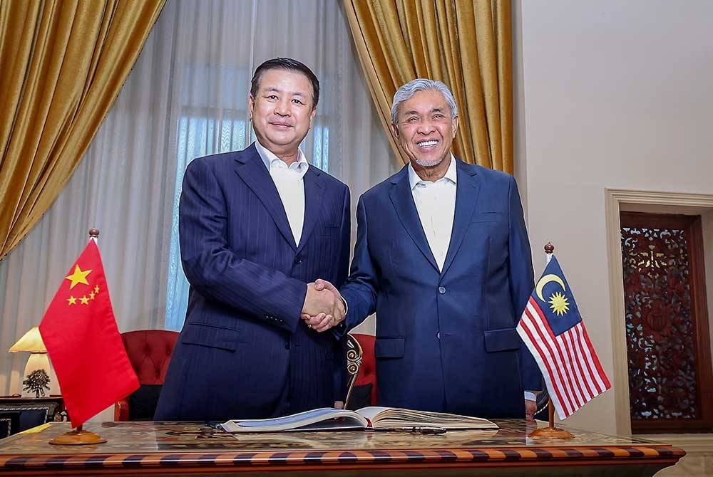 Timbalan Perdana Menteri, Datuk Seri Dr Ahmad Zahid Hamidi bersalaman dengan Wang Xiaohong semasa menerima kunjungan Penasihat Negara merangkap Menteri Keselamatan Awam China itu di Sri Satria pada Jumaat. - Foto Bernama